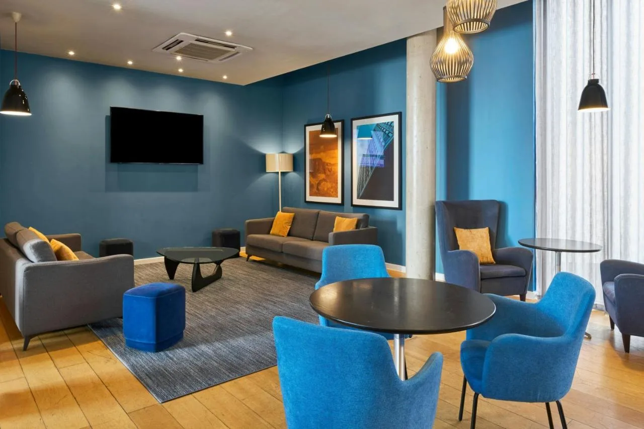 Lounge with blue chairs and a table at Four Points Flex by Sheraton Cardiff, Cardiff city centre