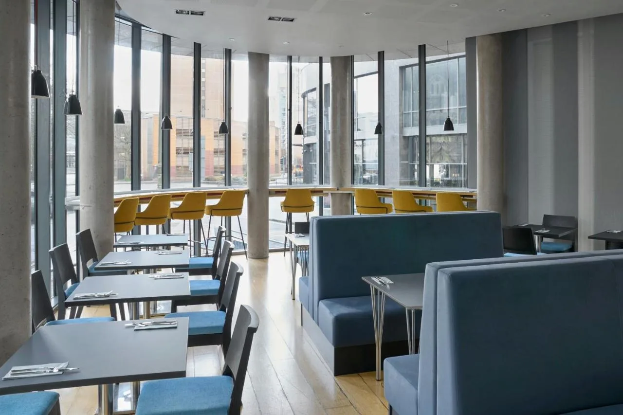 Restaurant with blue chairs and tables near windows at the Cardiff hotel