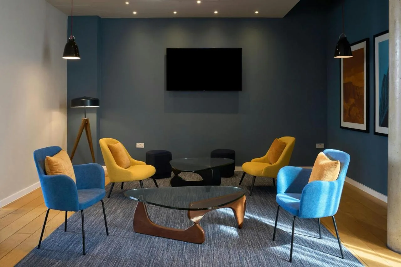 Waiting area with chairs, table and TV at Four Points Flex by Sheraton Cardiff